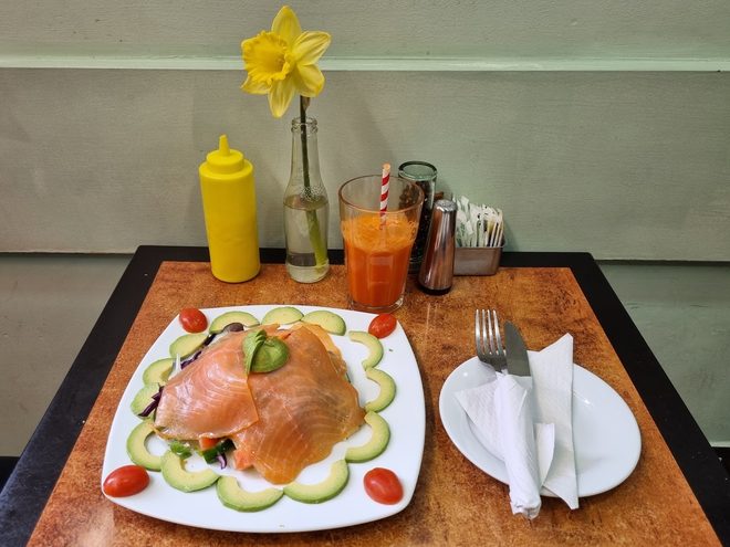 A salad plate laid up with juice, water and a daffodil in a vase