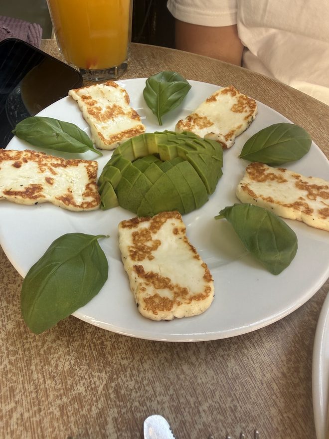 Halloumi and avocado with basil on a white plate